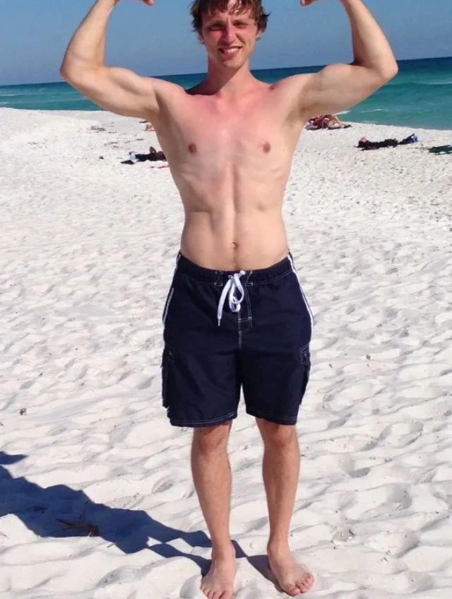 Young man meditating on the beach with hands in prayer pose